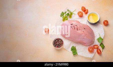 Filetto di tacchino crudo con erbe, spezie e pomodori ciliegini pronti per la cottura vista dall'alto, spazio per il testo Foto Stock