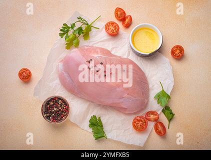 Filetto di tacchino crudo con erbe, spezie e pomodori ciliegini pronti per la cottura vista dall'alto Foto Stock