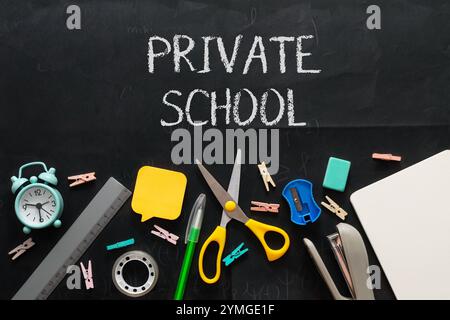 Forniture scolastiche private su una lavagna. Le forniture includono forbici, un righello, una matita e un orologio Foto Stock
