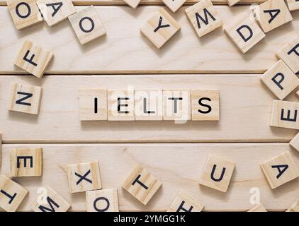 L'immagine presenta un collage di blocchi di legno che compongono IELTS, simboleggiando l'International English Language Testing System, spesso utilizzato per academ Foto Stock