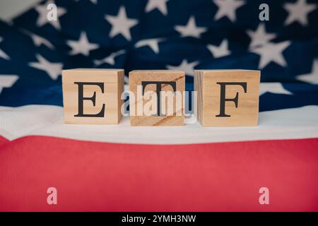 Blocco di legno con le lettere ETF. Il blocco è posto sopra una bandiera americana rossa e bianca. Il flag è sparso e il blocco ETF è pos Foto Stock