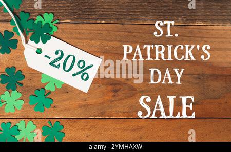 Contrassegna con un cartello verde e bianco degli sconti per il giorno di San Patrizio. L'etichetta è appesa a una foglia verde Foto Stock