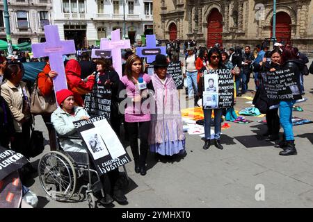 La Paz, Bolivia, 1 settembre 2014. La giornalista boliviana Paola Indira Cuentas si trova accanto alle attiviste per i diritti delle donne con cartelli neri con le foto e i nomi delle vittime delle femicidi in Plaza San Francisco mentre riferisce per le notizie colombiane NTN24 su una manifestazione per protestare contro la violenza contro le donne. Secondo un rapporto DELL'OMS nel gennaio 2013, la Bolivia è il paese con il più alto tasso di violenza contro le donne in America Latina, dal 2006 ci sono stati 453 casi di femminicidio. Parte della chiesa di San Francisco è sullo sfondo. Crediti: James Brunker / Alamy Live News Foto Stock