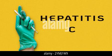 Persona che detiene una siringa con la parola epatite C riportata di seguito. Concetto di attenzione e responsabilità quando si tratta di maneggiare apparecchiature mediche Foto Stock