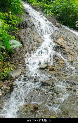 Piccola cascata lungo la strada per la cascata Tumpak Sewu in Indonesia Foto Stock