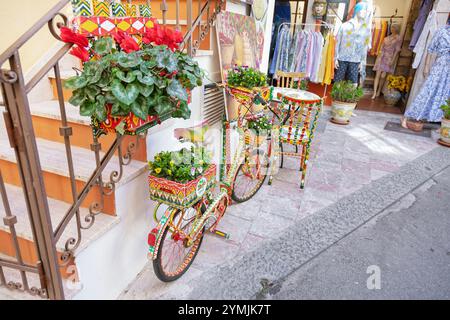 Vicolo della città vecchia pieno di opere d'arte, Taormina, Sicilia, Italia Foto Stock