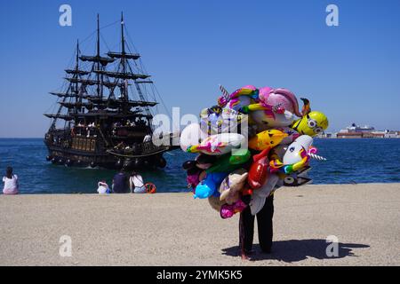 Venditore di mongolfiere in attesa dell'arrivo di una nave pirata a Salonicco, Grecia Foto Stock