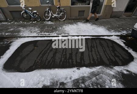 Monaco, Germania. 22 novembre 2024. Un'auto ha lasciato il segno dopo una nevicata notturna. Crediti: Felix Hörhager/dpa/Alamy Live News Foto Stock