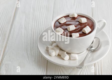 cioccolata calda con marshmallow in tazza su un tavolo di legno bianco Foto Stock