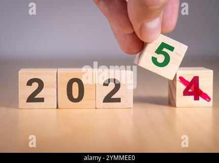 Mano cambiando il numero da 4 a 5 per simboleggiare il cambio di anno da 2024 a 2025. Foto Stock