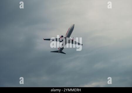 Lion Air Commercial Jet Plane Flying across Cloudy Sky, 19 ottobre 2024, Balikpapan, East Kalimantan, Indonesia Foto Stock