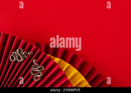 Capodanno cinese asia sfondo rosso dorato. Nuovo biglietto d'auguri per l'anno zodiaco Snake 2025. Sfondo piatto rosso con ventole natalizie, buste dei desideri, n. di serie Foto Stock