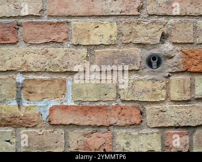 storico muro di mattoni con castello moderno - vecchio muro di mattoni medievale è stato rinnovato. Un castello moderno è un netto contrasto nel tempo Foto Stock