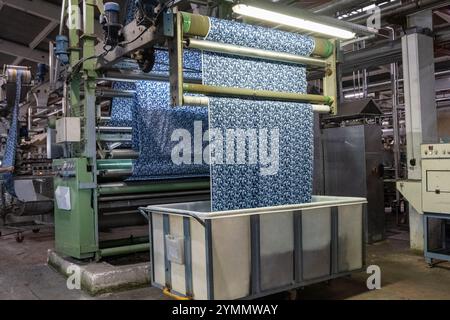 Linea di impianti industriali per macchine tessili in una fabbrica tessile. Foto Stock