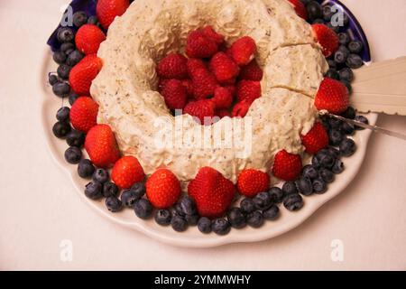taglio di una deliziosa torta di gelato al torrone decorata con frutti di bosco, vista dall'alto Foto Stock