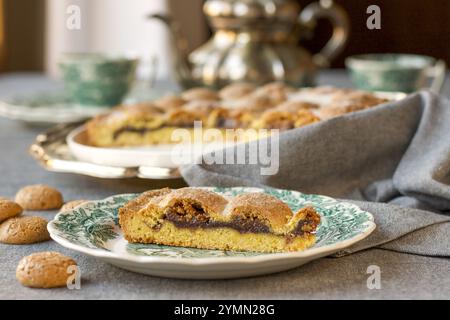 fetta di torta di amaretti su un piccolo piatto da dessert su un tovagliolo grigio Foto Stock