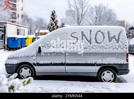 L'attacco dell'inverno, la prima nevicata, la parola neve scritta sul corpo dell'auto nella neve Foto Stock