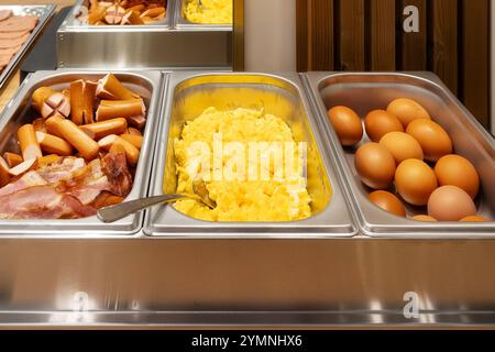 Colazione a buffet varia con salsicce calde, prosciutto, uova strapazzate e bollite Foto Stock