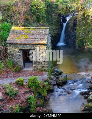 Un fiume che scorre sopra le cascate Rydal nel Lake District National Park, Cumbria, Regno Unito. Questo edificio risale al XVII secolo ed è conosciuto come Grot Foto Stock