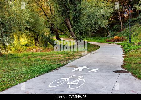 Segnaletica pedonale e ciclista nel parco. Alberi con fogliame verde. Foto Stock