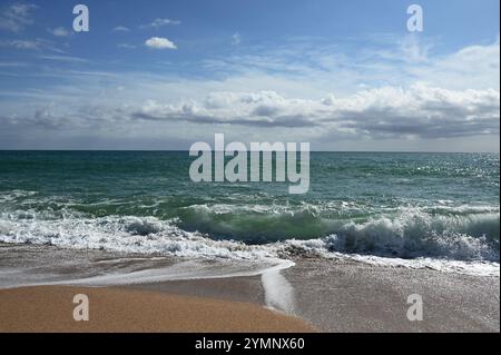 Le onde si infrangono sulle coste sabbiose di Sant Pol de Mar, catturando la serena bellezza del Mediterraneo. 8 ottobre 2024 Foto Stock