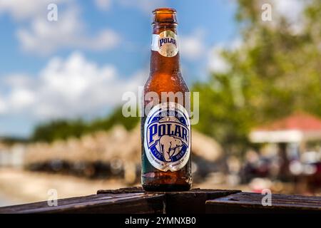 Una bottiglia di Polar Pilsener, una marca di birra venezuelana, su una ringhiera di legno presso il ristorante sulla spiaggia Brisa do Mar, Caracasbaaiweg, Jan Thiel, Curacao. Polar è la birra più venduta in Venezuela ed è ampiamente disponibile su Curacao a causa della sua vicinanza geografica e della stretta comunità di immigrati venezuelani. Birra polare dal Venezuela. Kòrsou Foto Stock