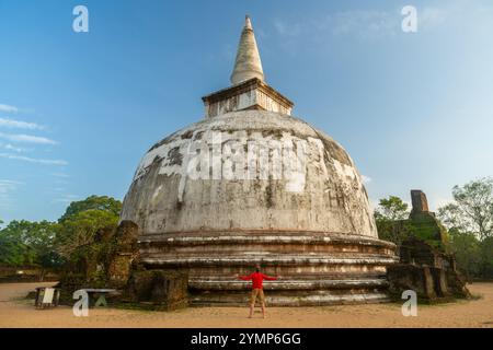 Uomo che cammina intorno Stupa antica città di Polonnaruwa, Sito Patrimonio Mondiale dell'UNESCO, Nord provincia centrale, Sri Lanka Foto Stock