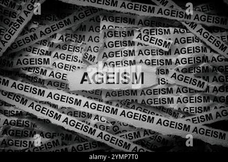 Strisce di giornali con le parole ageism scritte sopra. Bianco e nero. Primo piano. Foto Stock