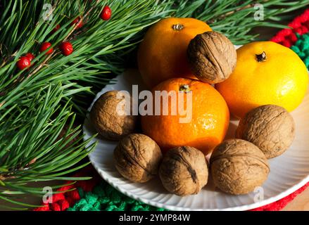 Mandarini e noci sullo sfondo di Capodanno. Decorazioni per il nuovo anno e il Natale. Foto Stock