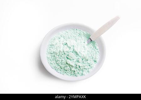 Polvere di argilla verde naturale in recipiente con cucchiaio isolato su sfondo bianco, elemento di design. Argilla commestibile. Polvere di alginato. Foto Stock