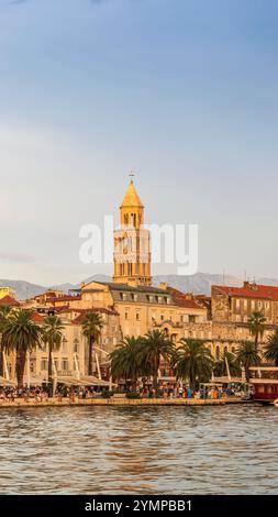 Tramonto sulla vivace passeggiata di Riva a Spalato, Croazia. Fiancheggiato da palme ed edifici storici, il lungomare è pieno di gente e colorfu Foto Stock