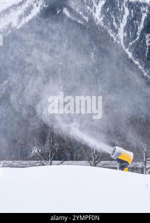 Canoni innevati che fanno neve finta in Planards skislope all'inizio della stagione. Chamonix, Francia. Verticale. Foto Stock