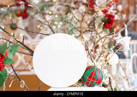 Decorazioni natalizie con cerchio bianco vuoto sui rami e sullo sfondo delle luci, mockup con spazio di copia per il testo. Decorazioni colorate per le vacanze Foto Stock