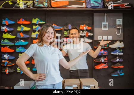 venditore di sesso femminile e maschile in piedi con il braccio aperto Foto Stock