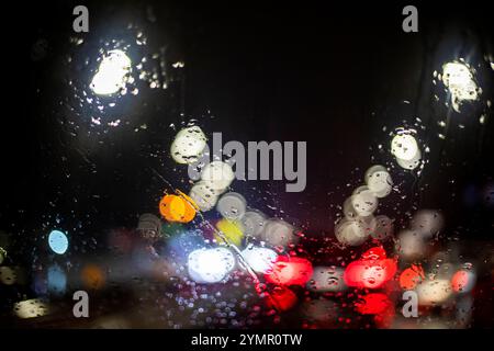 riflessi delle luci di stop rosse provenienti dal parabrezza di un'auto sotto la pioggia in un ingorgo. Sicurezza stradale. Scarsa visibilità Foto Stock