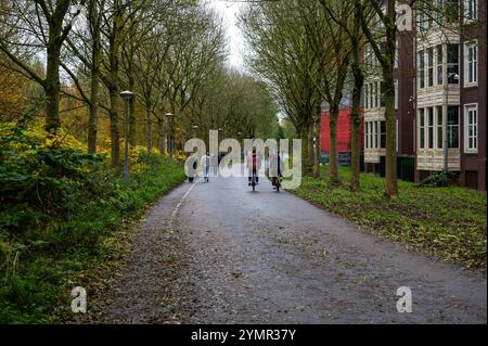 Ciclisti attraverso il giardino Tuinpark nut en Genoegen ad Amsterdam, Paesi Bassi, 15 novembre 2024 Foto Stock