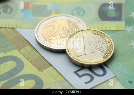 Monete diverse sulle banconote in euro, vista ravvicinata Foto Stock