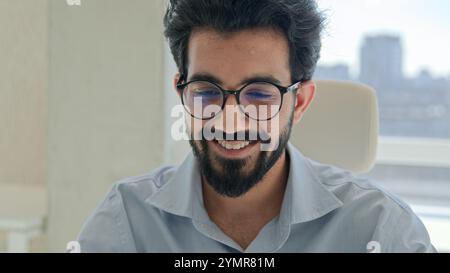 Mano di colpo che si muove scrivendo laptop uomo d'affari indiano arabo sorridente che lavora in remoto in ufficio felice uomo musulmano che scrive attività di programma Foto Stock