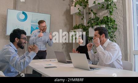 Diversi colleghi di aziende multinazionali colleghi di team celebrano la vittoria dei risultati uomini d'affari felici e felici e felici Foto Stock