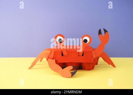 un progetto artigianale che assomiglia a un granchio. Il granchio è costituito da un cartone di uova di colore arancione, con pezzi di carta o cartone aggiuntivi per le gambe e l'artiglio Foto Stock
