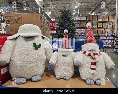 Adorabili e soffici decori natalizi di creature della neve con cappelli e sciarpe natalizie in mostra in un negozio. Perfetto per i temi dell'arredamento natalizio e. Foto Stock