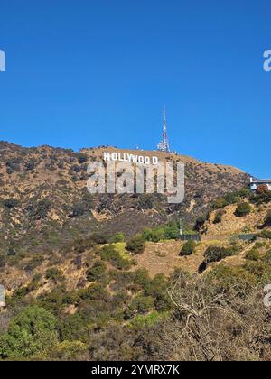 "L'iconica insegna di Hollywood in una giornata di sole, ambientata su un cielo azzurro e colline aspre. Perfetto per viaggi, luoghi di interesse e cultura di Los Angeles Foto Stock