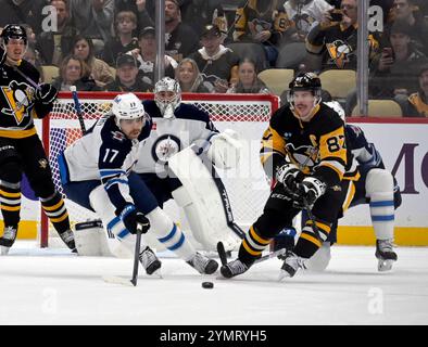 Pittsburgh, Stati Uniti. 22 novembre 2024. Il centro dei Winnipeg Jets Adam Lowry (17) sgombra il disco dal centro dei Pittsburgh Penguins Sidney Crosby (87) durante il primo periodo alla PPG Paints Arena di Pittsburgh venerdì 22 novembre 2024. Foto di Archie Carpenter/UPI. Crediti: UPI/Alamy Live News Foto Stock