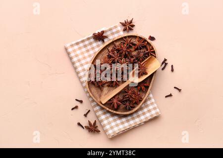 Piatto in legno con anice stellato, paletta e tovagliolo su sfondo colorato Foto Stock