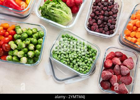 Contenitori in vetro con diversi prodotti freschi, come verdura e frutta, su uno sfondo chiaro. Vista dall'alto. Foto Stock