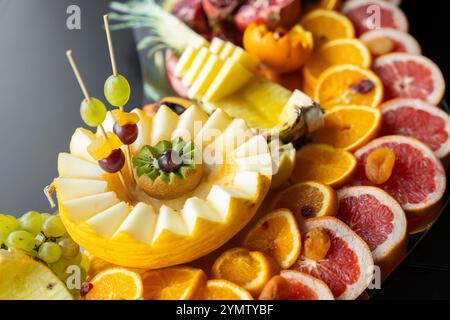 Mangiare all'evento. Piatto di frutta vivace e ben organizzato con una varietà di frutta fresca Foto Stock