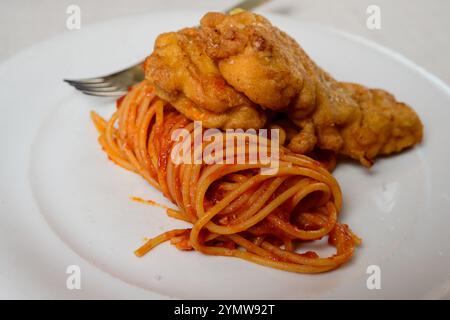 Cotoletta di vitello piccata alla milanese con spaghetti e salsa di pomodoro Foto Stock