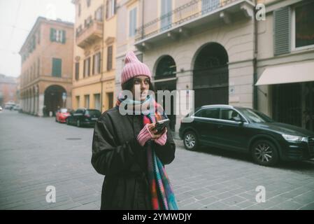 Una pittoresca scena di strada invernale con una giovane donna vestita con una vivace sciarpa colorata Foto Stock