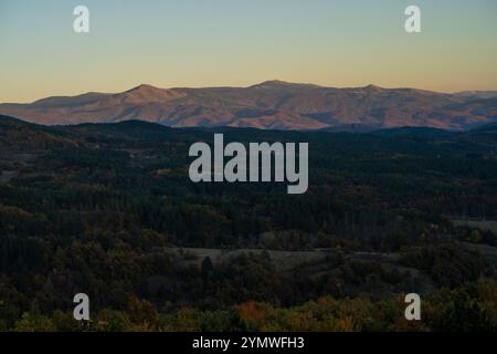 Tramonto con le cime del monte Golija all'orizzonte nebbioso Foto Stock