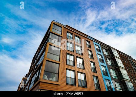 Moderno edificio di appartamenti con balconi in vetro ed elementi industriali. Foto Stock